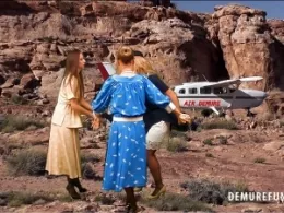 Demure Island Damsles at Demure Fun | Unfortunately the plane bursts a tyre on landing so the ladies are stranded on a windy desert island. They are not pleased and rip off Fiona's pilot uniform before setting off to a distant beach to seek rescue.