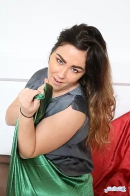 Lacy May at Satin Silk Fun | We find Lacy May looking rather sensual in satin, she is wearing a shiny, soft, black satin blouse and a long green pleated satin skirt. As she moves around, every now and then she reveals the lace tops of her black stockings and she has our attention as she slides the hem of her skirt upwards for us