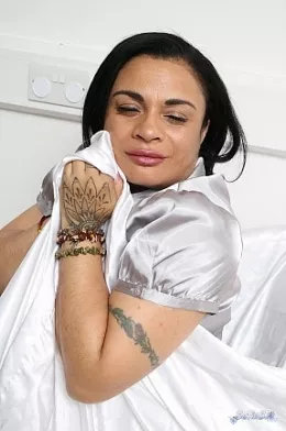 Toya S at Satin Silk Fun | Wearing a shiny grey button up satin blouse and a short above the knee  purple satin skirt, Toya is a dream for satin lovers as she sits back on the satin sheets inviting you to come closer and feel the softness and sensuality of the satin, perhaps you would like an invite inside but not today, thats for another time