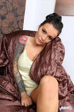 Charley Atwell at Satin Silk Fun | Charley Atwell is sitting upon some shiny brown satin sheets whilst wearing a long, soft and shiny, white satin chemise. She enjoys the feel of the fabric against her skin, flashing you her cleavage and her knickers from time to time