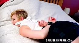 Helen Stephens at Damsels in Peril | Housewife Helen Stephens wakes to find herself very tightly tape tied and cleave gagged, laying on her bed. She has no idea who did this or how it happened but what she does know is that all she can do is mumble through the cloth of the gag, writhe around and squeak her shoes together as she attempts to get free