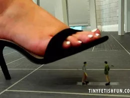 Kay at Tiny Fetish Fun | Sat on her kitchen table, Kay is wearing a bright red cotton strap top and a short mid length flowing summer style skirt, it is a rather warm day so she welcomes the tinies onto her kitchen and decides that they are need to destroying