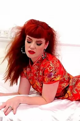 Zoe Page at Satin Silk Fun | Redhead Zoe Page is wearing a patterned red satin cheongsam and a pair of red lace panties