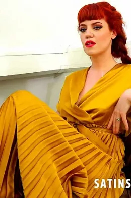 Zoe Page at Satin Silk Fun | Zoe Page is in a long golden satin wrap around dress with a pleated bottom skirt part and a pair of yellow panties