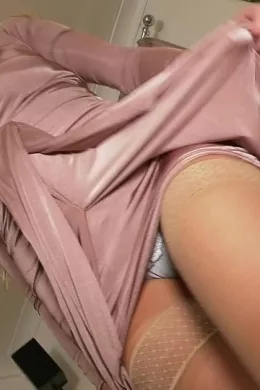 Minnie at Upskirt Glamour | Behind-the-scenes video footage from shoot with Minnie wearing a stylish pastel dress (sans bra), pale blue briefs/panties, tan holdup stockings with patterned tops, and high-heeled shoes that stay on throughout, in elegant tease to topless.